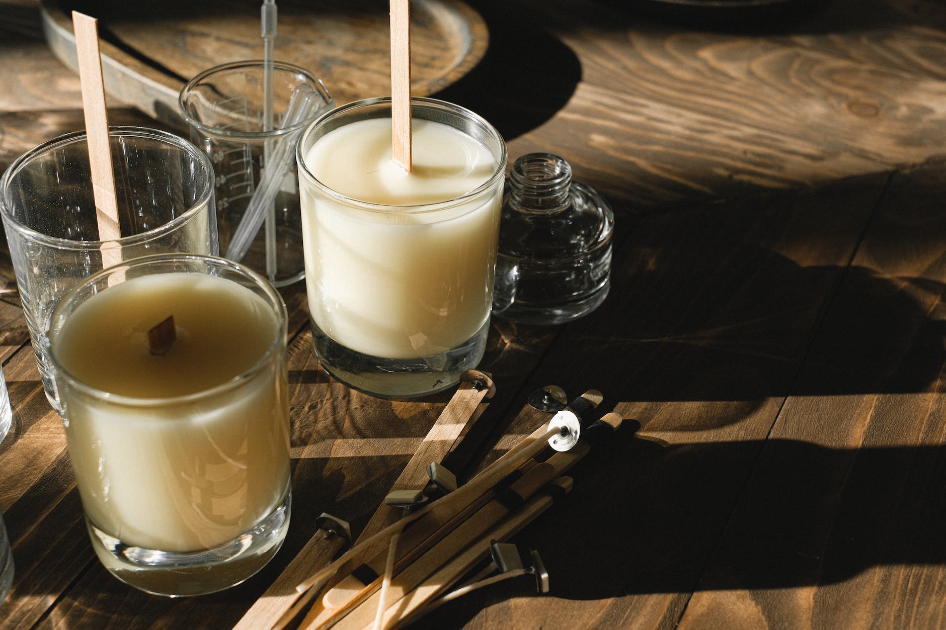 glasses with organic candles on wooden table